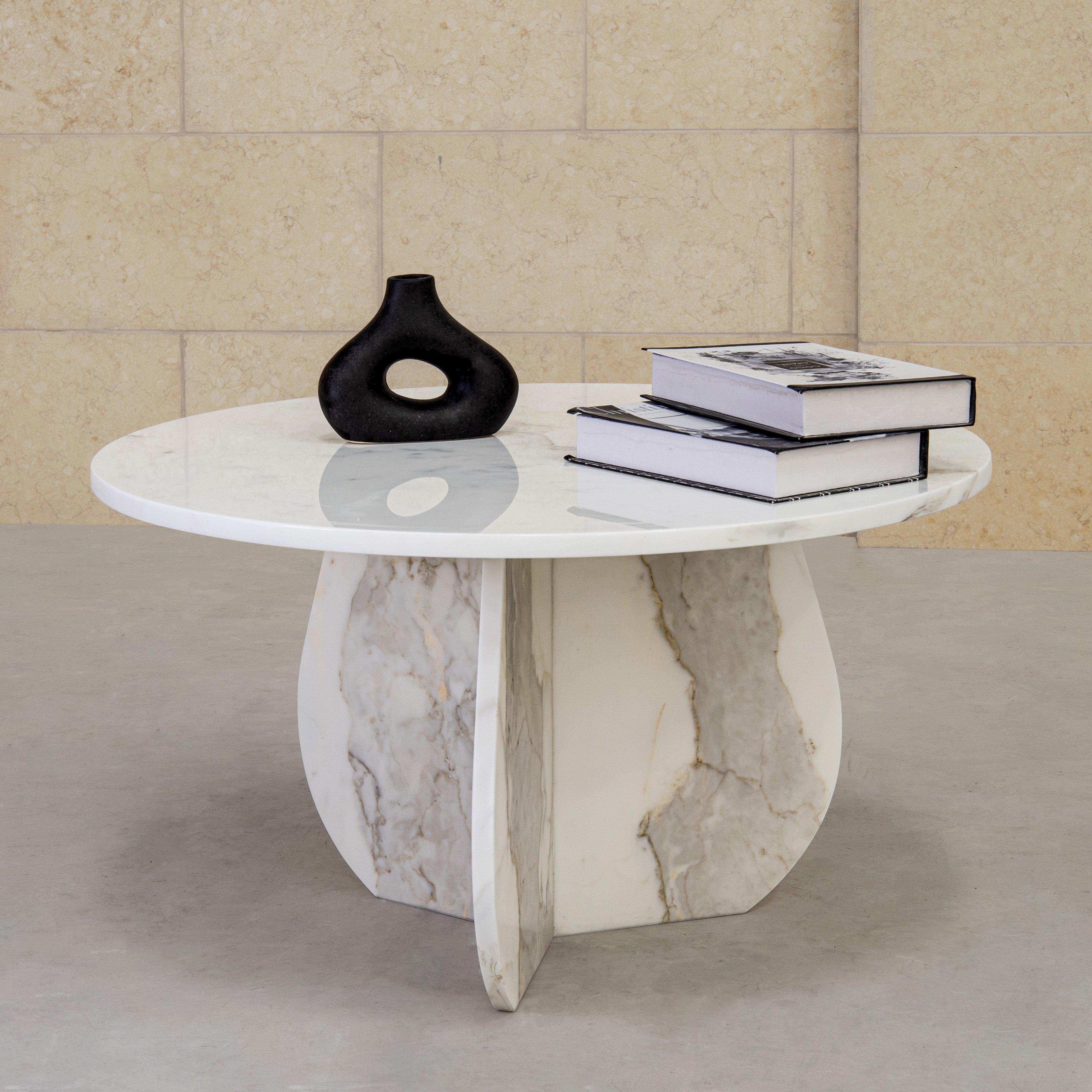 Round marble coffee table with two books on it and black vase ceramic decoration