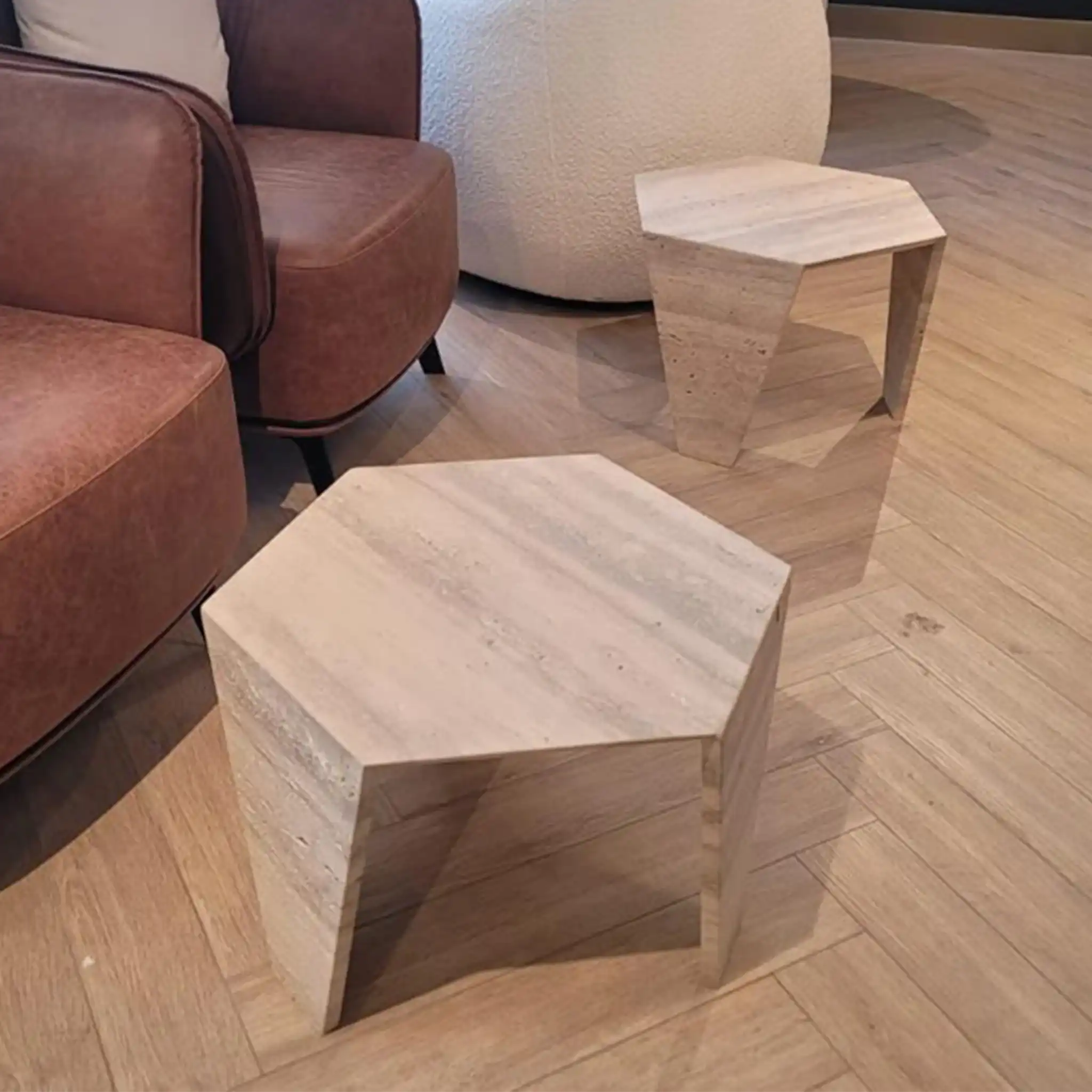 Hexagonal Narwin side tables from Marbeya Charm on a wooden floor with a brown armchair in the background.