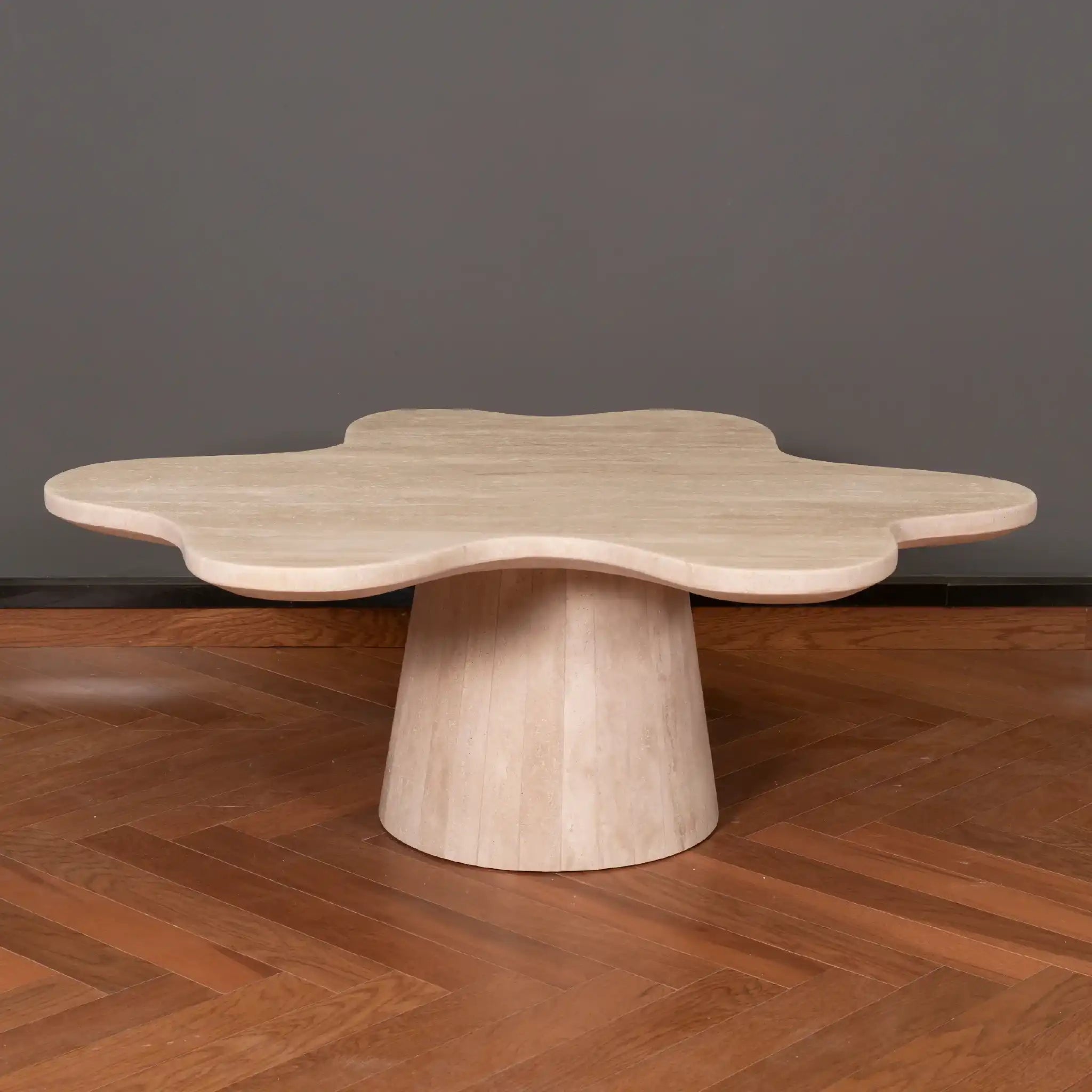 Petalo Travertine coffee table with a unique design on a wooden floor against a dark wall