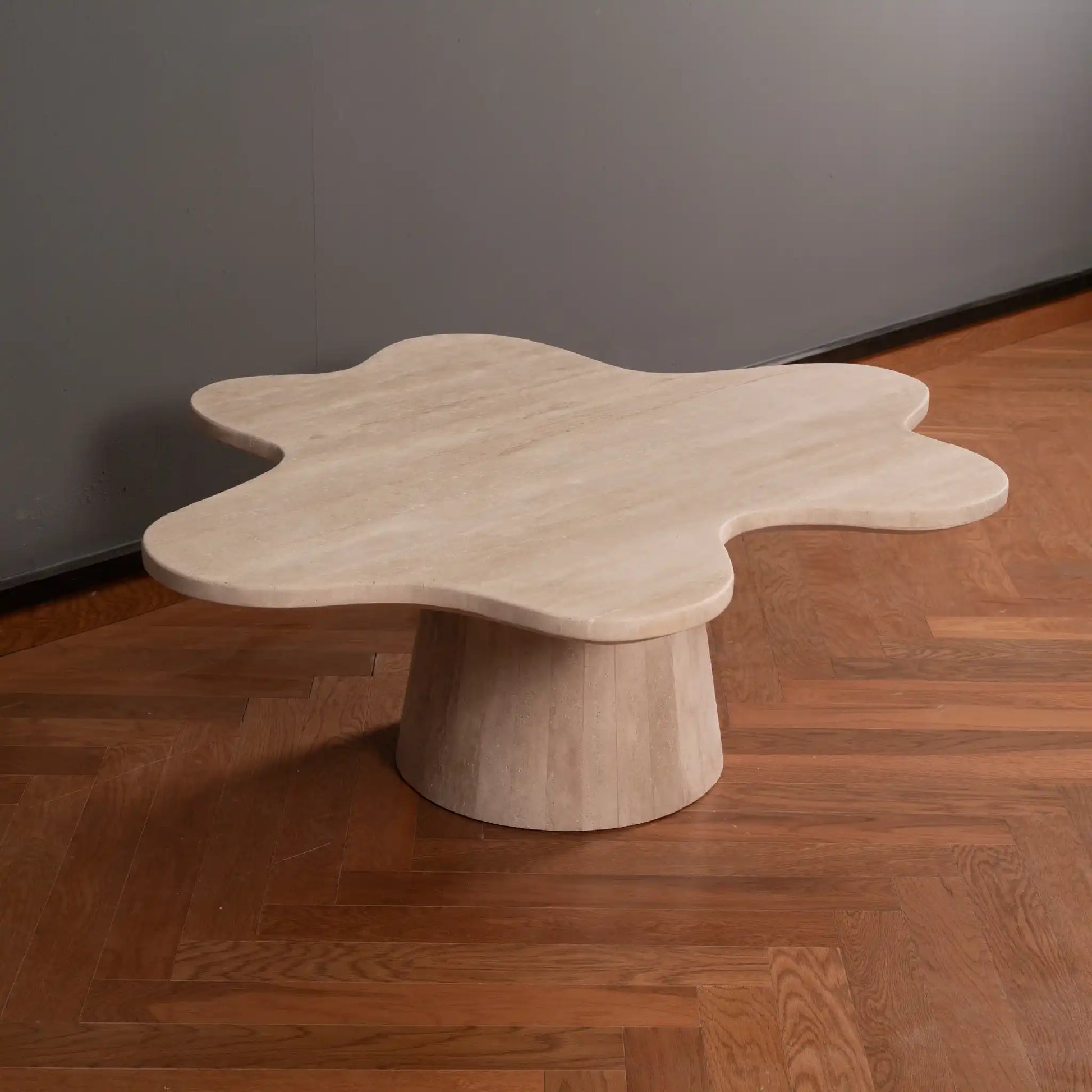Flower-like shaped Travertine Coffee table on a wooden floor with a gray wall background